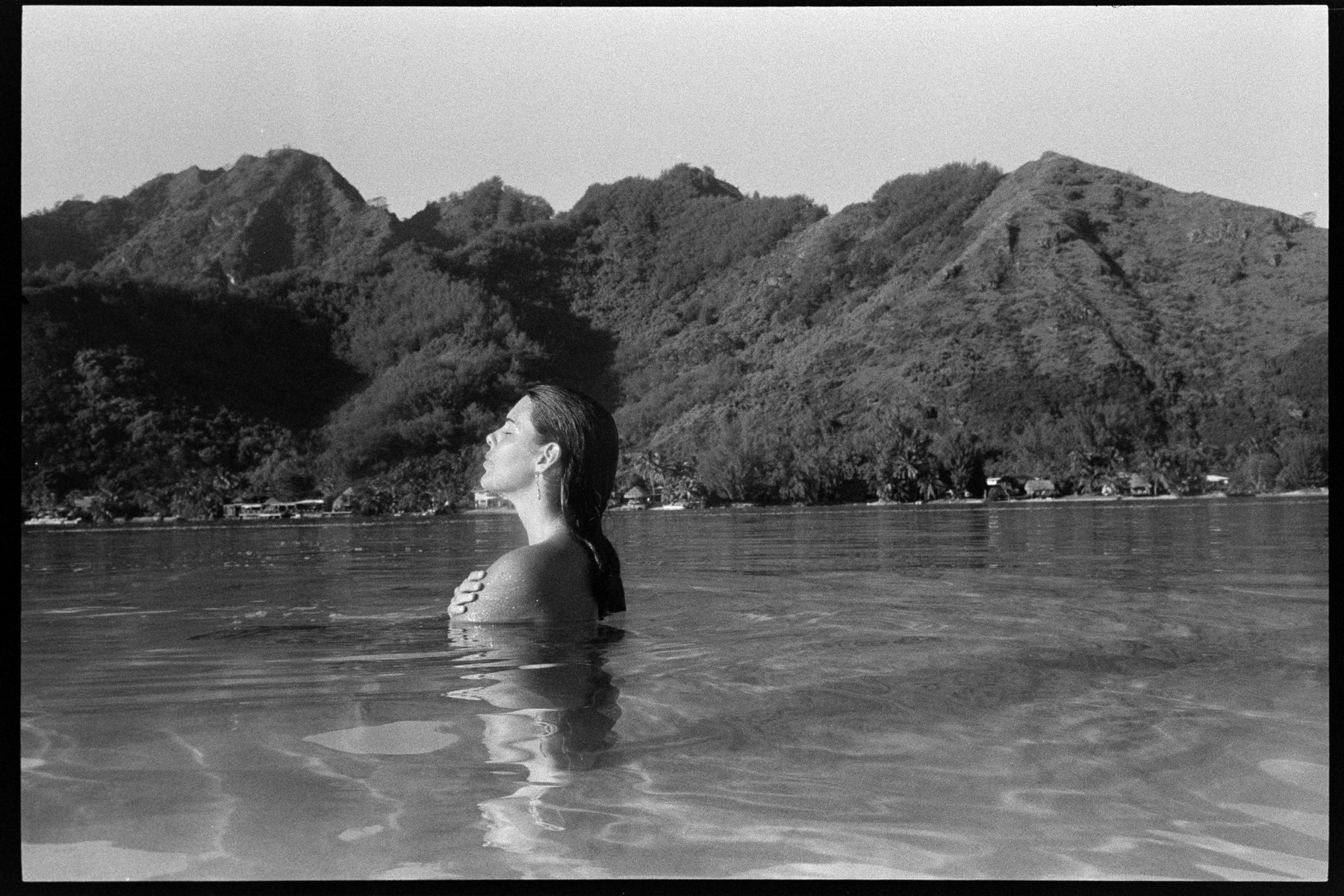 Aquila shoulder-deep in the lagoon at Moorea, black-and-white film